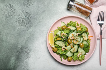 Plate with tasty cucumber salad on color background