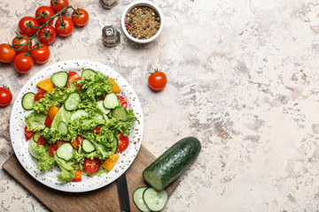 Plate with tasty cucumber salad on grey background