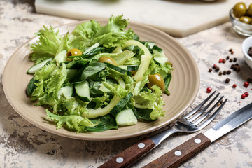 Plate with tasty cucumber salad on grey background