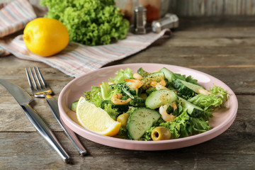 Plate with tasty cucumber salad on table