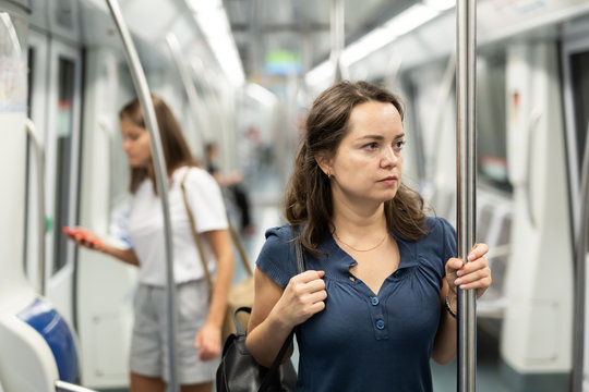 Nice women with handbag in subway car. High quality photo