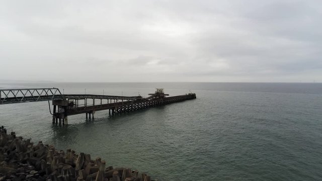 Aerial view Raynes jetty coastal quarry mining marine cargo landmark North Wales rising forward