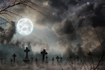 Fototapeta na wymiar Misty graveyard with old creepy headstones under full moon on Halloweeen