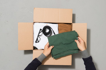 Man hands putting clothes to donate box