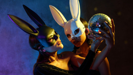 Portrait of two young cute Asian women in black and white rabbit mask posing with small disco ball...