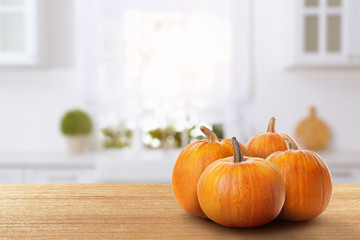Fresh pumpkins on wooden table in kitchen. Space for text - Powered by Adobe