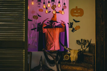 Holiday celebration symbols on brick wall. Funny wise wizard on a Halloween background.