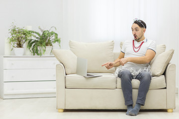 Photo of bearded man excited about something using laptop.