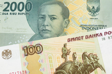 A macro image of a Russian one hundred ruble note paired up with a grey two thousand rupiah bank note from Indonesia.  Shot close up in macro.
