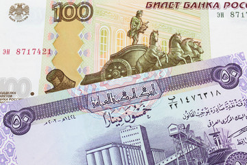 A macro image of a Russian one hundred ruble note paired up with a purple fifty dinar bill from Iraq.  Shot close up in macro.