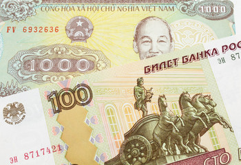 A macro image of a Russian one hundred ruble note paired up with a yellow one thousand dong bill from Vietnam.  Shot close up in macro.