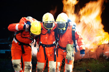 Firefighters are helping workers by pulling out of the burning building.