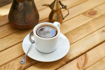 White cup of strong coffee on wooden background