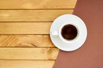 White cup of strong coffee on wooden and brown background Copy space