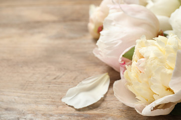 Fototapeta na wymiar Beautiful peonies on wooden background, closeup. Space for text