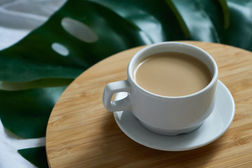 White cup of coffee latte on exotic background. Breakfast concept