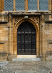 Fototapeta na wymiar Heavy wood arched door way set into the abbey in Sherborne, United Kingdom. 
