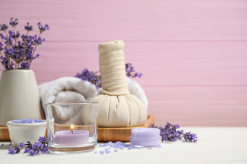 Cosmetic products and lavender flowers on white wooden table