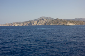 Fototapeta na wymiar Greece. Rhodes island. Rest at the sea. Euro-trip. Sea water surface. Mountains in the background.