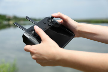 Woman with modern drone controller outdoors, closeup © New Africa