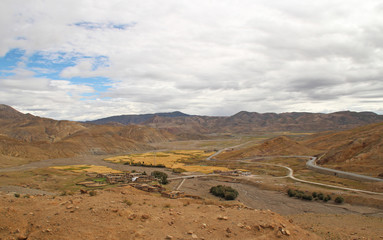 Tibetan Village and the highland barley field in cloudy day, Tibet, China 