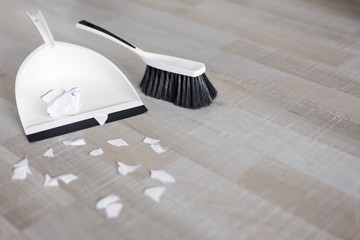 scoop, brush and ripped pieces of paper and copy space on wooden floor