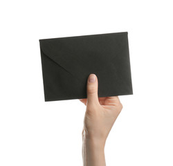 Woman holding black paper envelope on white background, closeup