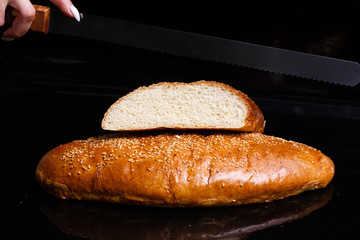 Homemade pastries. Crispy white bread cut with a knife.