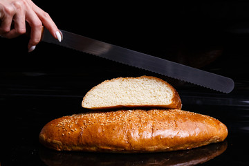 Homemade pastries. Crispy white bread cut with a knife.