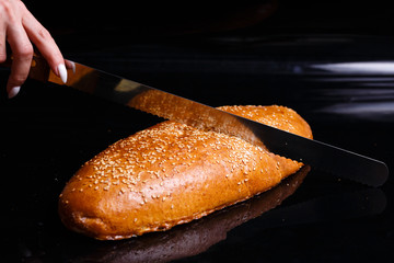 Homemade pastries. Crispy white bread cut with a knife.