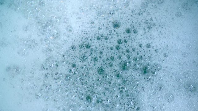 Top view of foamy soapy water texture. White suds and clean water.