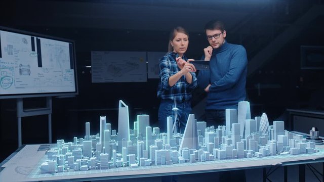 Architect and Engineer have Discussion, Use Augmented Reality Smartphone to Design Sustainable 3D Megalopolis City Model. Futuristic Office with Architectural Designers. Graphical Animation VFX 