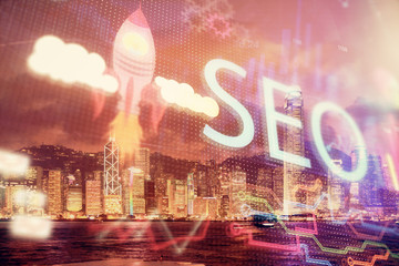 SEO hologram on city view with skyscrapers background double exposure. Search optimization concept.