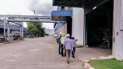 Engineers are walking through industry manufacturing factory, Safety patrol in manufacturing area, Cooperation by engineer and technician to check abnormality in factory