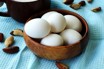 eggs in a basket, nuts , a cup of milk, 
blue napkin