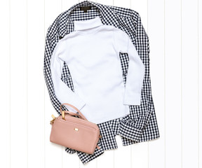 White turtleneck, handbag and plaid shirt on a light background