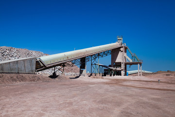 Mynaral, Kazakhstan: Mine (quarry) of chalk mineral Jambyl Cement plant, conveyor and hopper on clear blue sky.