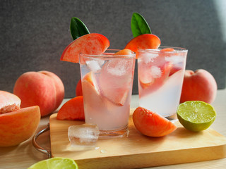 Pink color peach mocktail glass on a wooden cutting board for the summer drink concept.