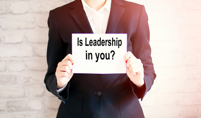 woman showing white card with IS LEADERSHIP IN YOU word . Business
