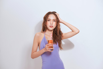  smiling pretty girl in mini dress drinking cocktail isolated over white background