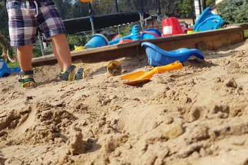 Little boy playing in the sand - close up photo of the sandy legs