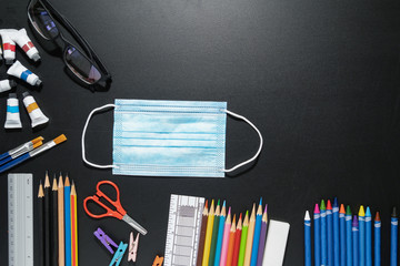 School is back to open after the epidemic coronavirus. School supplies stationery group of pencils, pens,ruler,color on blackboard. Back to school concept.