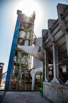 Mynaral, Kazakhstan: Jambyl Cement plant. Silhouette of main cement tower, clinker kiln, silo and pipes.