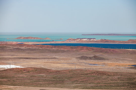 View on Balkhash lake coast. Panorama of desert and blue water. New houses for cement plant workers. Mynaral, Kazakhstan