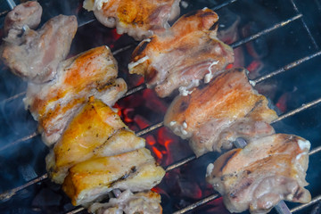 pork ribs on skewers over an open fire grill barbecue charcoal