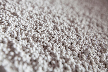 White granules (pellets) of phosphoric (phosphate) fertilizers on chemical plant warehouse....
