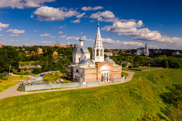 panoramic view of an old church in summer on a green hill against a cloudy sky background