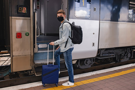 Young man wearing protective face maskgoing to enter the intercity train.