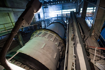 Grey ball mill (factory mill) in factory workshop of phosphoric fertilizers plant. Panorama view. No people.