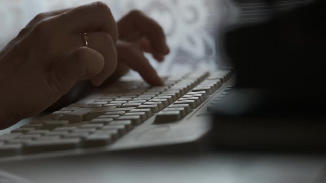 Married girl with ring on her hand prints letter or document on computer. Close up female hands pressing buttons on retro vintage white computer keyboard in daylight.